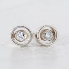 Made-to-order is our take on geometric round diamond earrings. Two 2.5mm round white diamonds are set "floating" between a modern gold ellipse frame. With this style, you get the same impact of traditional bezel set round diamond earrings with a smaller price tag. These are petite and understated- perfect for everyday wear and gift giving. Unique - Modern - Minimalist - Geometric - High Fashion Designer Look These earring settings are approximately 5mm x 5.7mm, weigh 1.2 g and the diamonds are 0 Modern Diamond Earrings, Vintage Diamond Earrings, Soft Opening, Bezel Set Earrings, Round Diamond Earrings, Diamond Earrings Studs Round, Edgy Jewelry, Earrings Geometric, Eco Friendly Jewelry