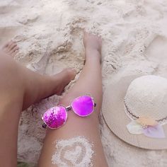 a person laying on the beach with white powder all over their body and sunglasses in front of them