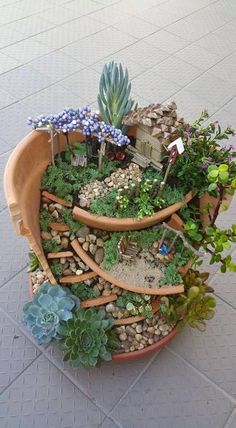 a potted planter with succulents, rocks and plants in it