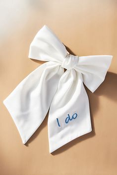 The I Do Satin Hair Bow by Anthropologie Weddings exudes timeless elegance, making it an impeccable choice for both pre-bridal festivities. | I Do Satin Hair Bow by Anthropologie Weddings in White, Women's, Polyester/Iron Satin Hair Bow, Bow Bandeau, Pre Bridal, Bridal Headwear, Anthropologie Wedding, Crystal Chandelier Earrings, Gift For Bride, Candles For Sale, Wedding Bows