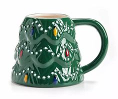 a green ceramic mug with christmas lights on it