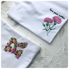 two embroidered napkins with flowers on them