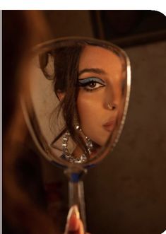 a close up of a person holding a magnifying glass in front of a mirror