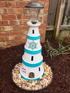 a white and blue lighthouse made out of rocks