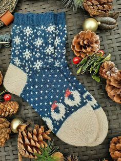 a knitted christmas sock surrounded by pine cones and other holiday decorations