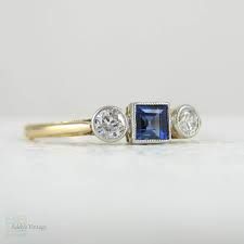 an engagement ring with two diamonds and a blue sapphire