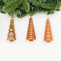 three wooden ornaments hanging from a christmas tree