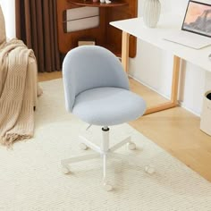 a blue office chair sitting on top of a white rug in front of a computer desk