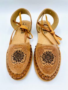 These stunners are unique and cute! The details in the flower design is stunning while the tie around straps are not easily found for most huaraches. Genuine Leather Light brown with flower design Handmade in Mexico Pro-tip! These fit true to size. If you are a half size and have a wider foot, size up. If you have a more narrow foot, size down. Adjustable Flower Sandals, Spring Adjustable Ankle Strap Huarache Sandals, Traditional Adjustable Hand-tooled Huarache Sandals, Handmade Adjustable Huarache Sandals For Spring, Traditional Adjustable Huarache Sandals For Spring, Adjustable Lace-up Huarache Sandals, Adjustable Lace-up Huarache Sandals For Beach, Adjustable Brown Huarache Sandals With Ankle Strap, Adjustable Ankle Strap Brown Huarache Sandals