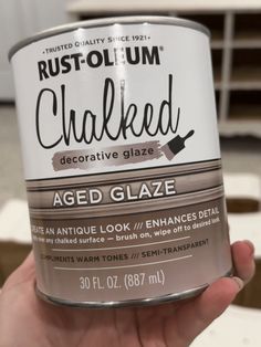 a hand holding a can of rust - olium chalked decorative glaze