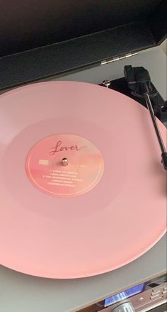 a pink record player sitting on top of a table