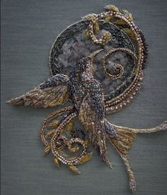 an intricately designed brooch with beads and feathers