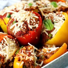 stuffed peppers with meat, cheese and herbs in a metal pan on a white table