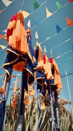 a bunch of kites that are flying in the air over some plants and trees