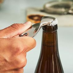 a person is opening a bottle with a opener