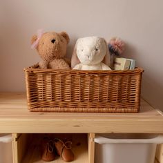 two stuffed animals sitting in a basket on top of a shelf