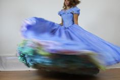 a woman in a blue dress is dancing