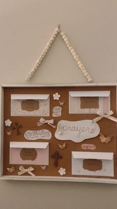 a cork board with some writing on it and paper decorations hanging from the wall above