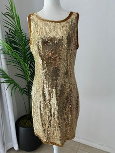 Stunning, gold sequin, mini, sleeveless, shift dress, perfect for New Years Eve. In overall great vintage condition, with only notable issue being a tiny patch of missing sequins on the back near the right arm pit, easily replaceable and not very noticeable. Dress is fully lined and zips up the back with a hook and eye closure at the top. No designers tag or labels, would best fit a modern size 8-10.   Measurements Chest 40in/101.5cm Waist 32in/81.5cm Hips 40in/101.5cm Length 36in/91.5 (strap to Gold Embellished Sleeveless Sequin Dress, Gold Sleeveless Mini Dress With Contrast Sequin, Gold Embellished Sleeveless Mini Dress, Gold Mini Dress With Contrast Sequin For Summer, Gold Sleeveless Sequin Fabric For Party Season, Gold Sequin Dress For Summer, Gold Sequin Fabric For Party Season, Gold Sleeveless Sequin Summer Dress, Gold Sleeveless Sequin Dress For Summer