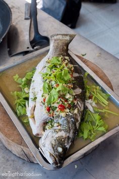 a fish in a pan with vegetables on it