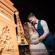 a bride and groom kissing in front of the eiffel tower at night, paris