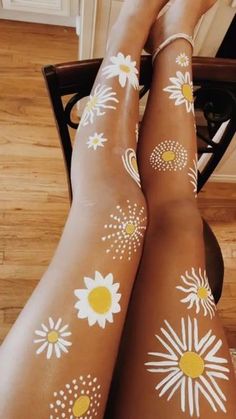 woman with sunflowers painted on her legs sitting in front of a computer desk