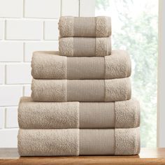 towels stacked on top of each other in front of a window