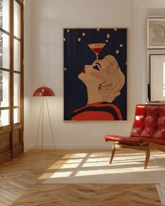 a red chair sitting in front of a painting on the wall next to a window