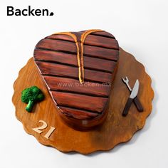 a wooden heart shaped cake with broccoli on it