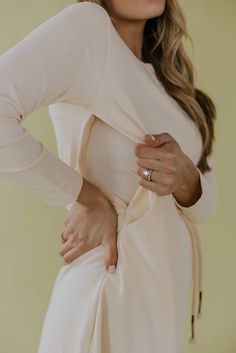 a woman with her hands on her hips wearing a white dress and holding her hand on her hip