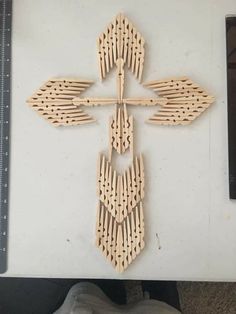 a cross made out of wood sitting on top of a table next to a ruler