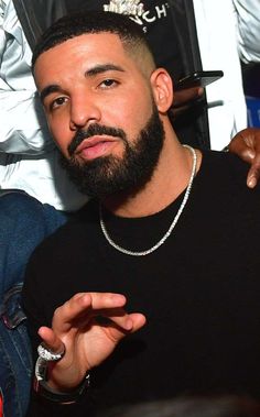 a close up of a person with a beard and wearing a black t - shirt