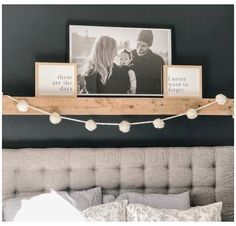 a bed with two pictures on the wall above it and a string of lights hanging from the headboard