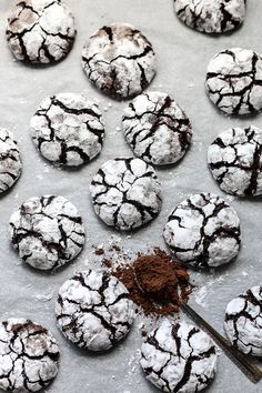 chocolate crinkle cookies on a baking sheet with powdered sugar and brown sprinkles