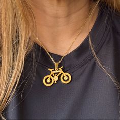 a woman wearing a gold necklace with a bike on it