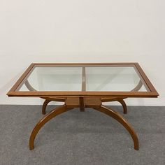 a wooden table with glass top on carpeted floor