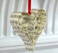 a heart shaped ornament hanging from a red string with sheet music notes on it