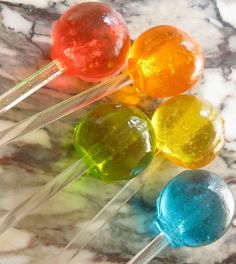 four lollipops sitting on top of a marble table