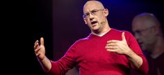 a man in a red sweater giving a speech