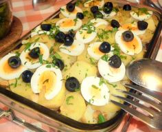 an egg dish with black olives and parsley on top is ready to be eaten