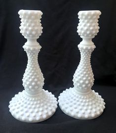 two white candlesticks sitting next to each other