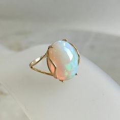 This stunning ring is set in 14k Solid Yellow Gold with Natural Ethiopion Opal with utmost precision. It is an unique statement gemstone ring for nearly every occasion and is completely hassle-free jewelry. ITEM DETAILS * GEM: Opal * GEM SIZE: 12X16mm * GEM SHAPE: Oval * GEM WEIGHT: 5.80 carats * Gold Purity: 14KT * Gold Weight: 1.64 gram * Total Weight of the Ring: 2.80 gram The Gold purity is guaranteed and it comes with authentic 14KT gold hallmark. Since my items are handmade, they are absol Fine Jewelry 14k Gold Opal Ring, 14k Gold Opal Ring Fine Jewelry, Fine Jewelry 14k Gold Opal Ring With Polished Finish, 14k Gold Opal Ring With Polished Finish, 14k Gold Opal Ring With Prong Setting, Oval Opal Ring With Prong Setting In 14k Gold, Dainty Opal Ring, Natural Opal Ring, Handmade Jewelry Box