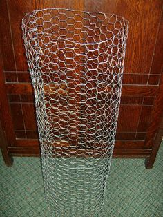 a tall metal vase sitting on top of a green tile floor