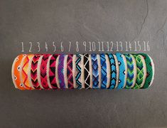 a bunch of different colored bracelets sitting on top of a table next to each other