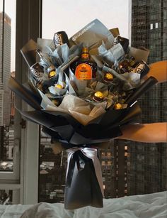 a bouquet of chocolates wrapped in black paper and tied to a bed with a city view