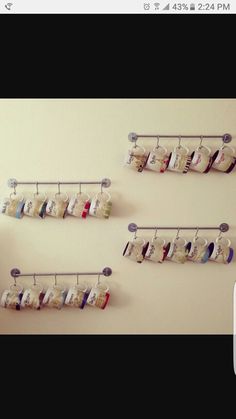 three mugs are hanging on the wall with cups attached to them, and one is filled with coffee