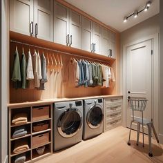 a washer and dryer in a room with clothes hanging on the wall next to it