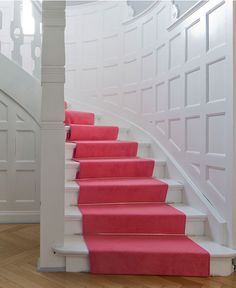 red carpeted stairs leading up to a white staircase