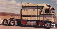 a large semi truck is parked on the side of the road in an empty lot