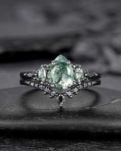 a close up view of a ring with an aqua green stone in the center and white diamonds around it